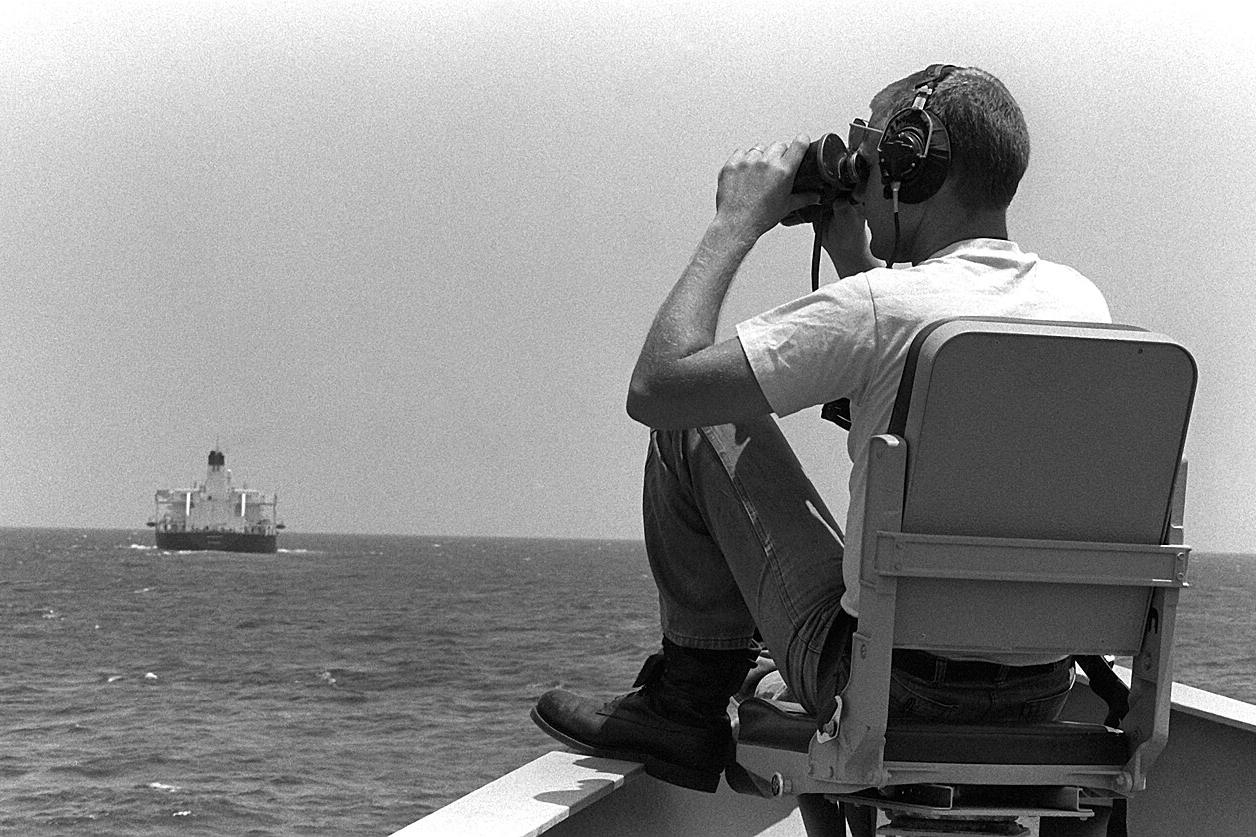 Моряк ВМС США ведет поиск мин с носа ракетного фрегата «Николас» в ходе сопровождения конвоя в рамках операции Earnest Will, июнь 1988 года
